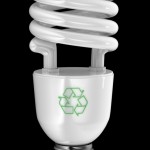 Energy saving light bulb with recycling symbol over black